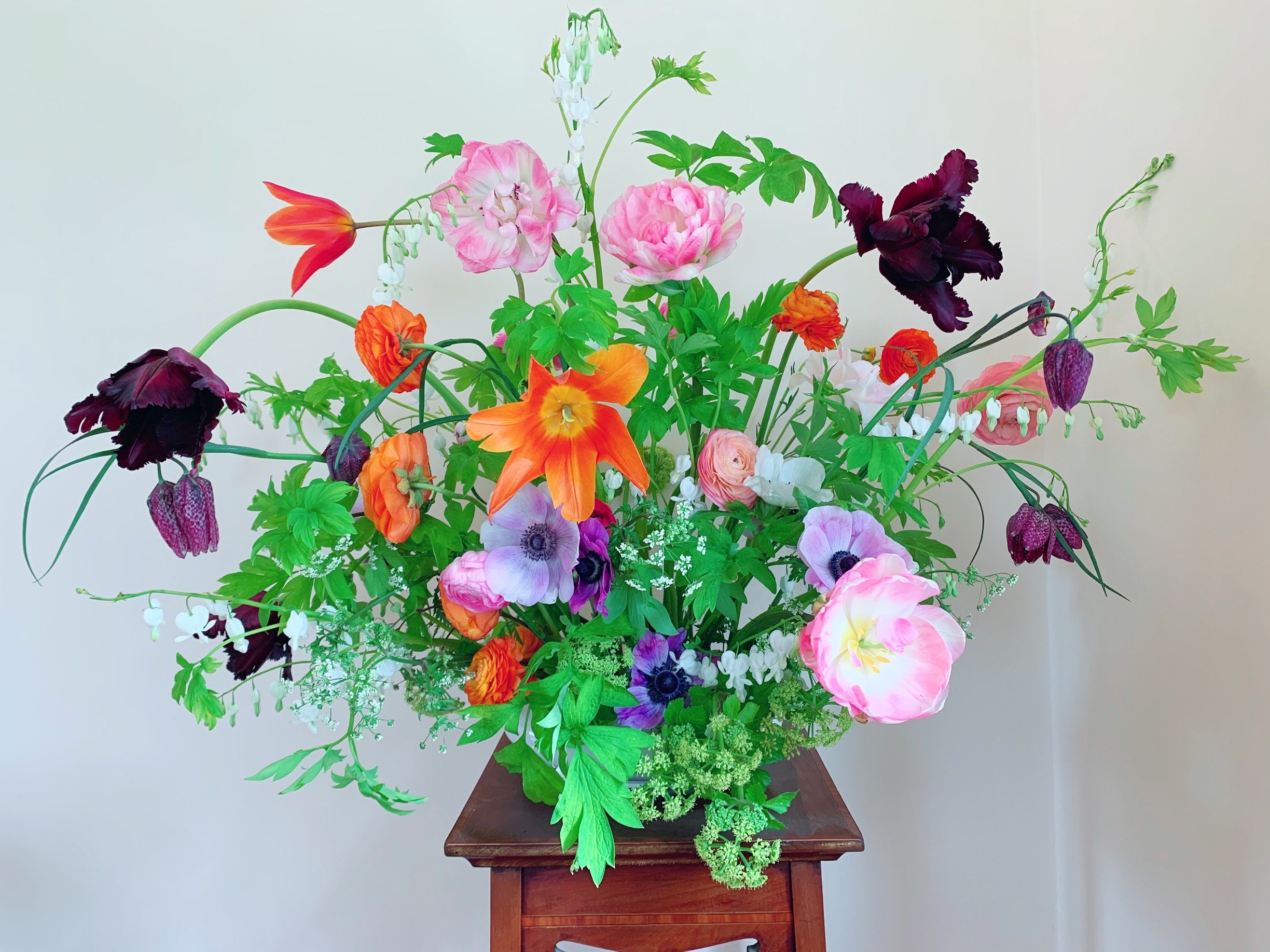 Bouquet of flowers, orange lilac, pink and red with vibrant green leaves